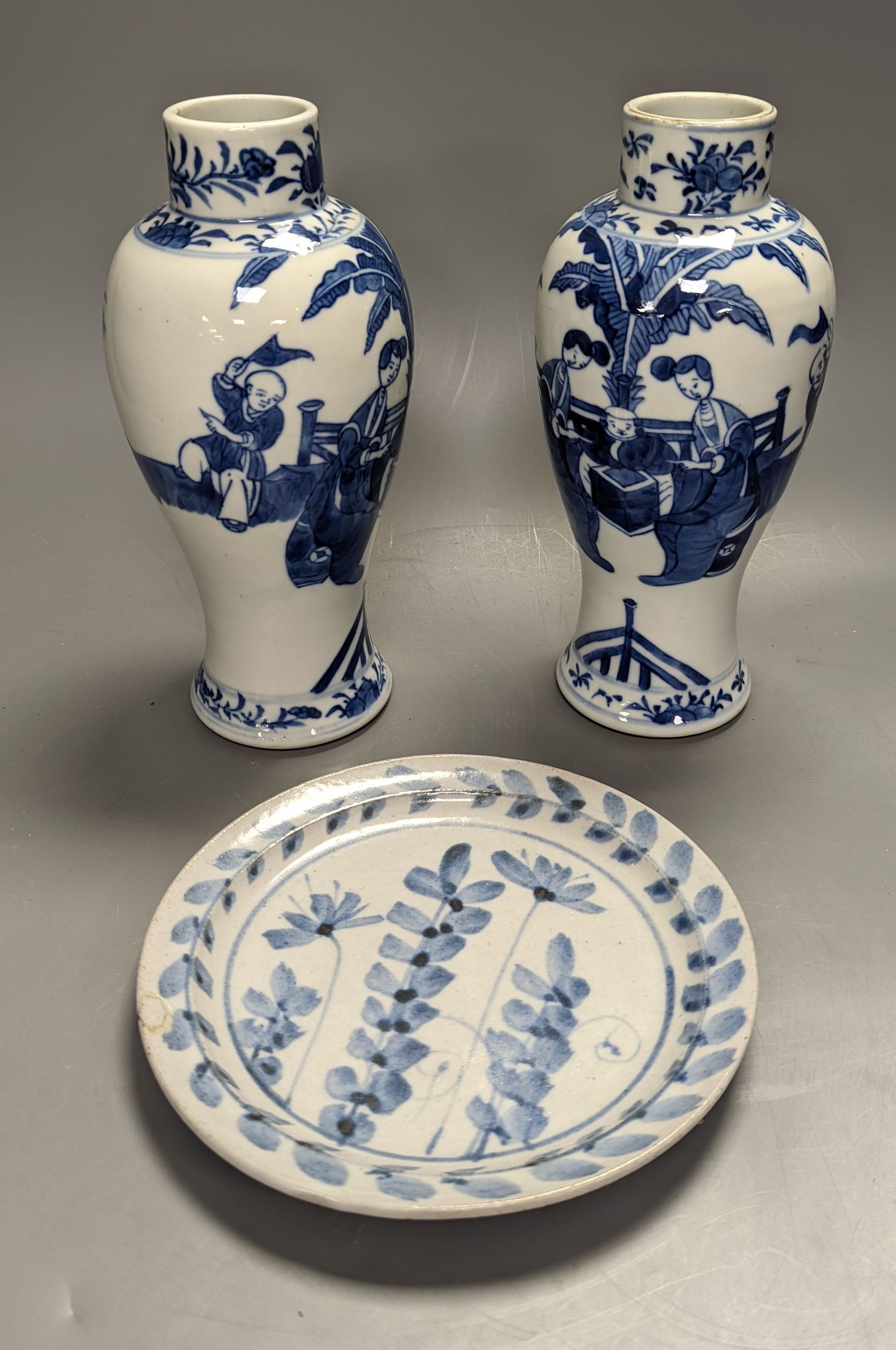 A pair of Chinese figural blue and white vases, drilled bases, height 25cm, and a plate